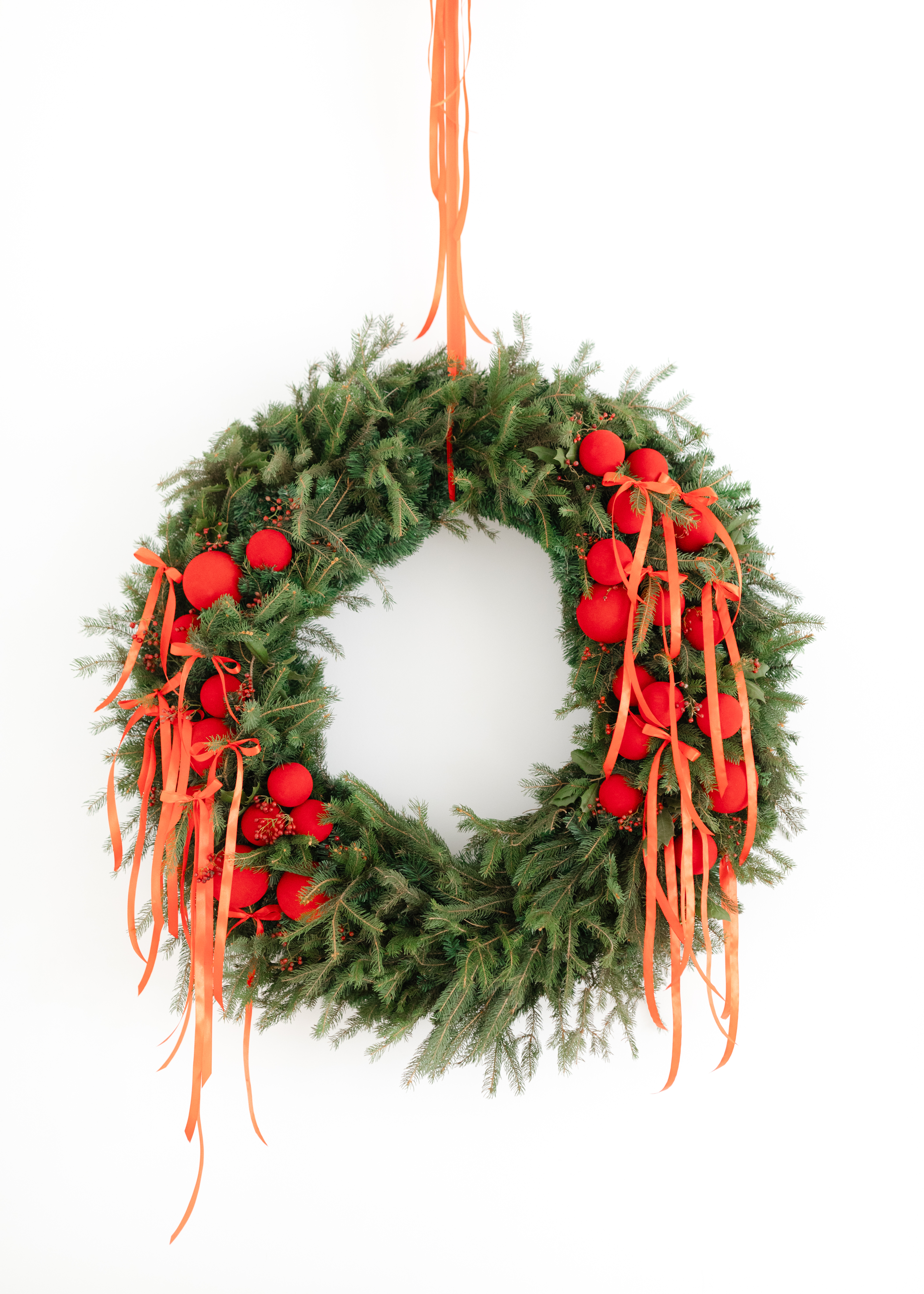 Evergreen holiday garland with ornaments along a mantel