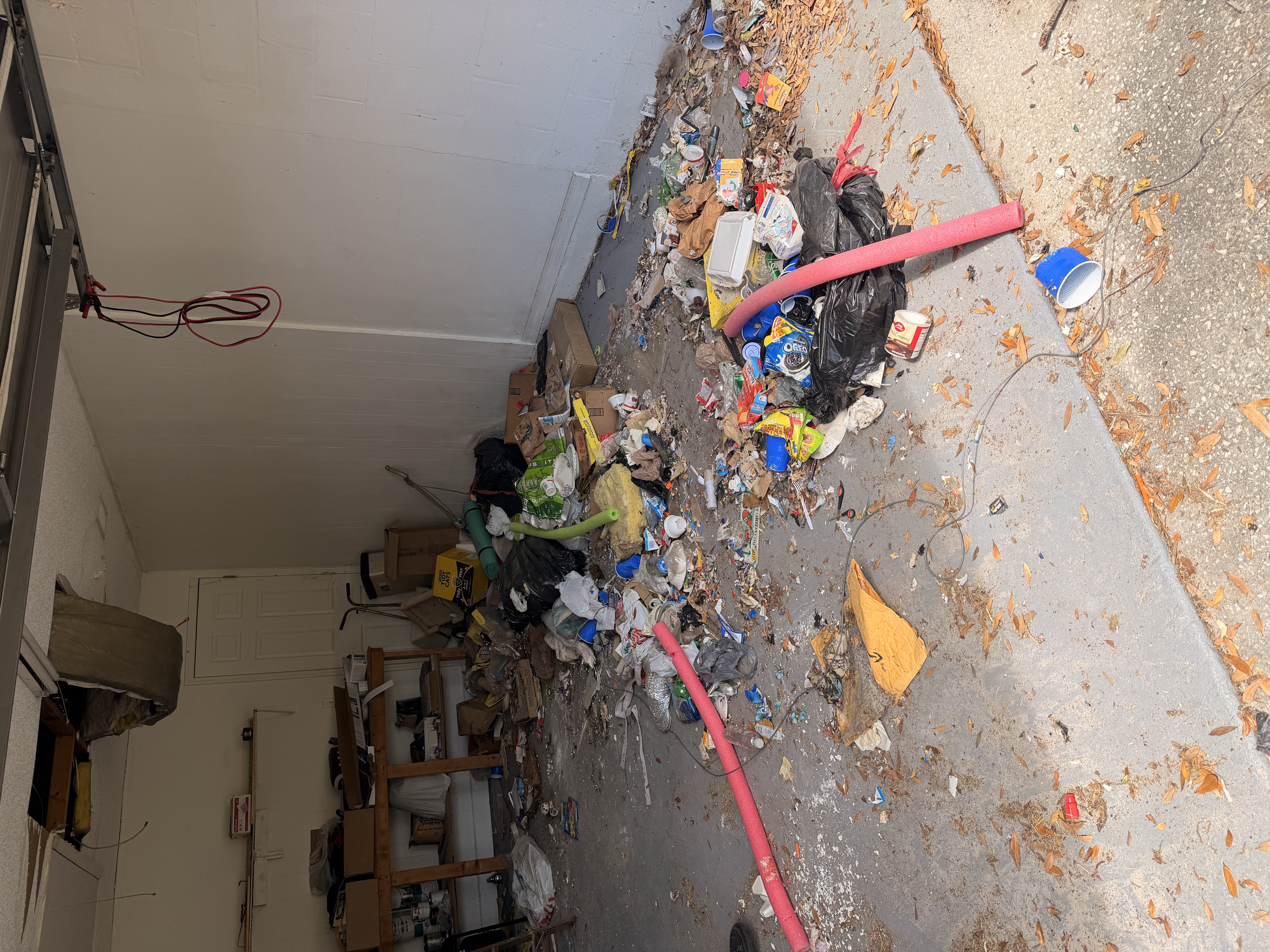 Garage in Lakeland before cleanout with boxes and trash