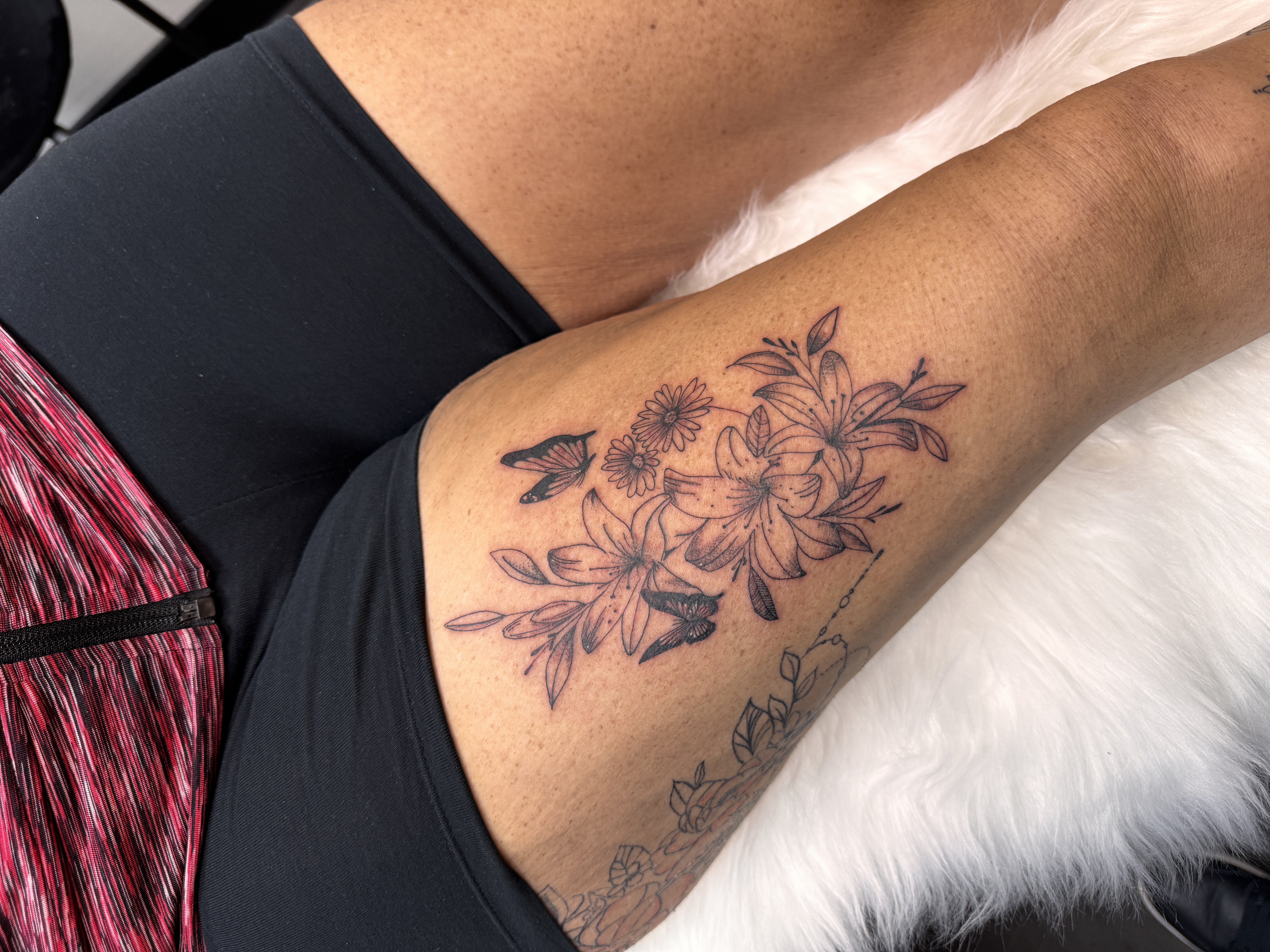 Botanical floral and butterfly thigh tattoo by XXII Ink