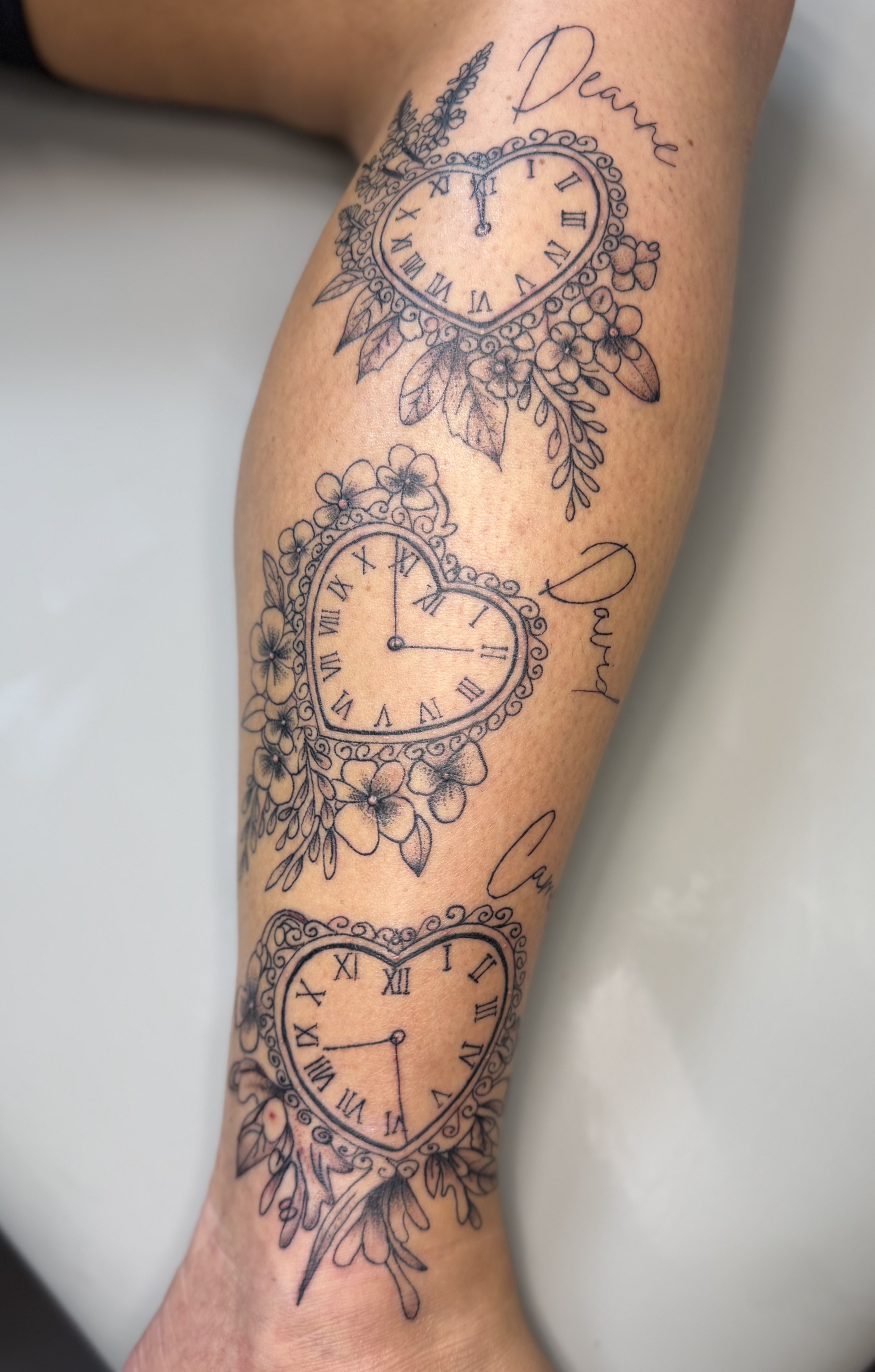Heart-shaped clock and floral memorial tattoos by XXII Ink