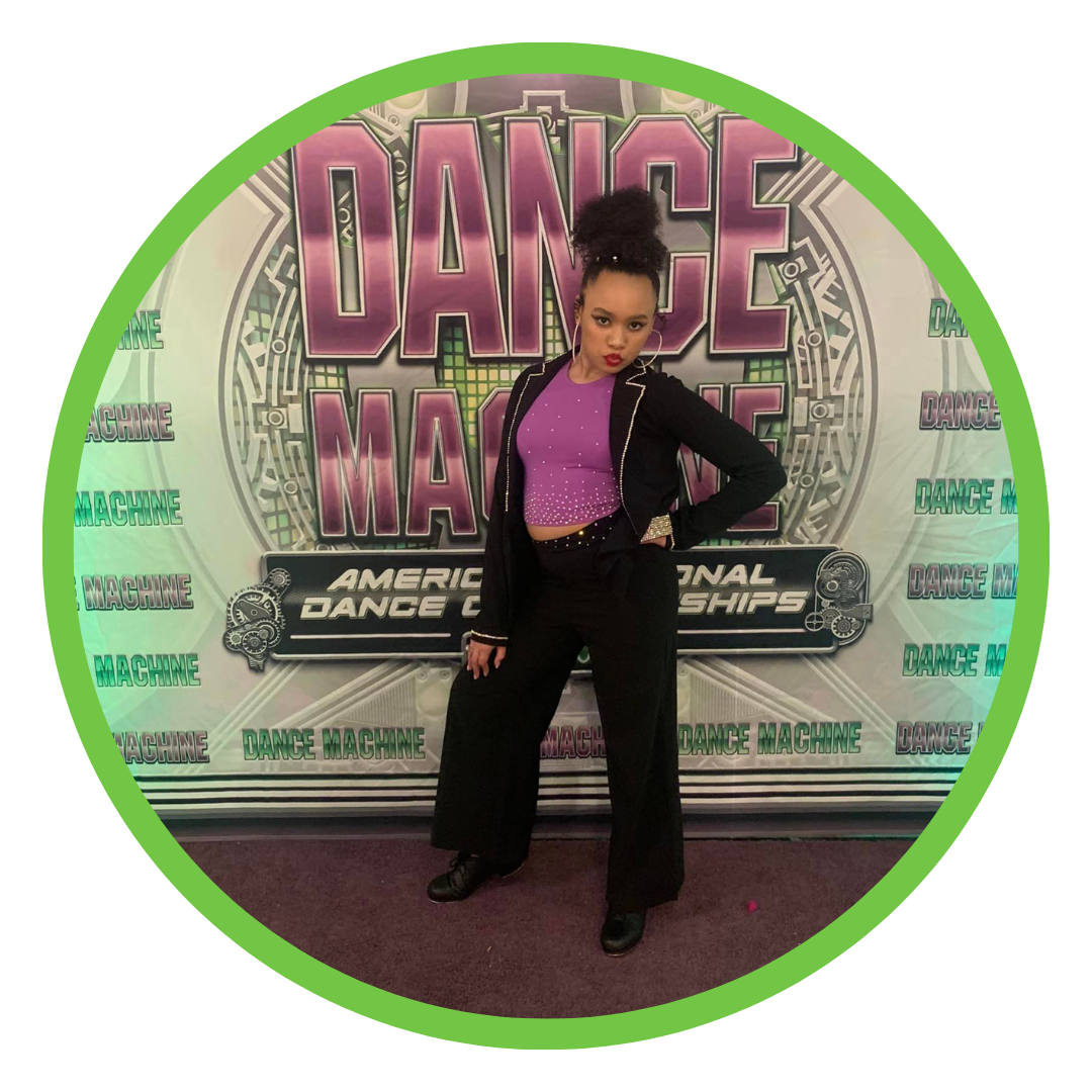 Dancer in purle and black costume in front of backdrop