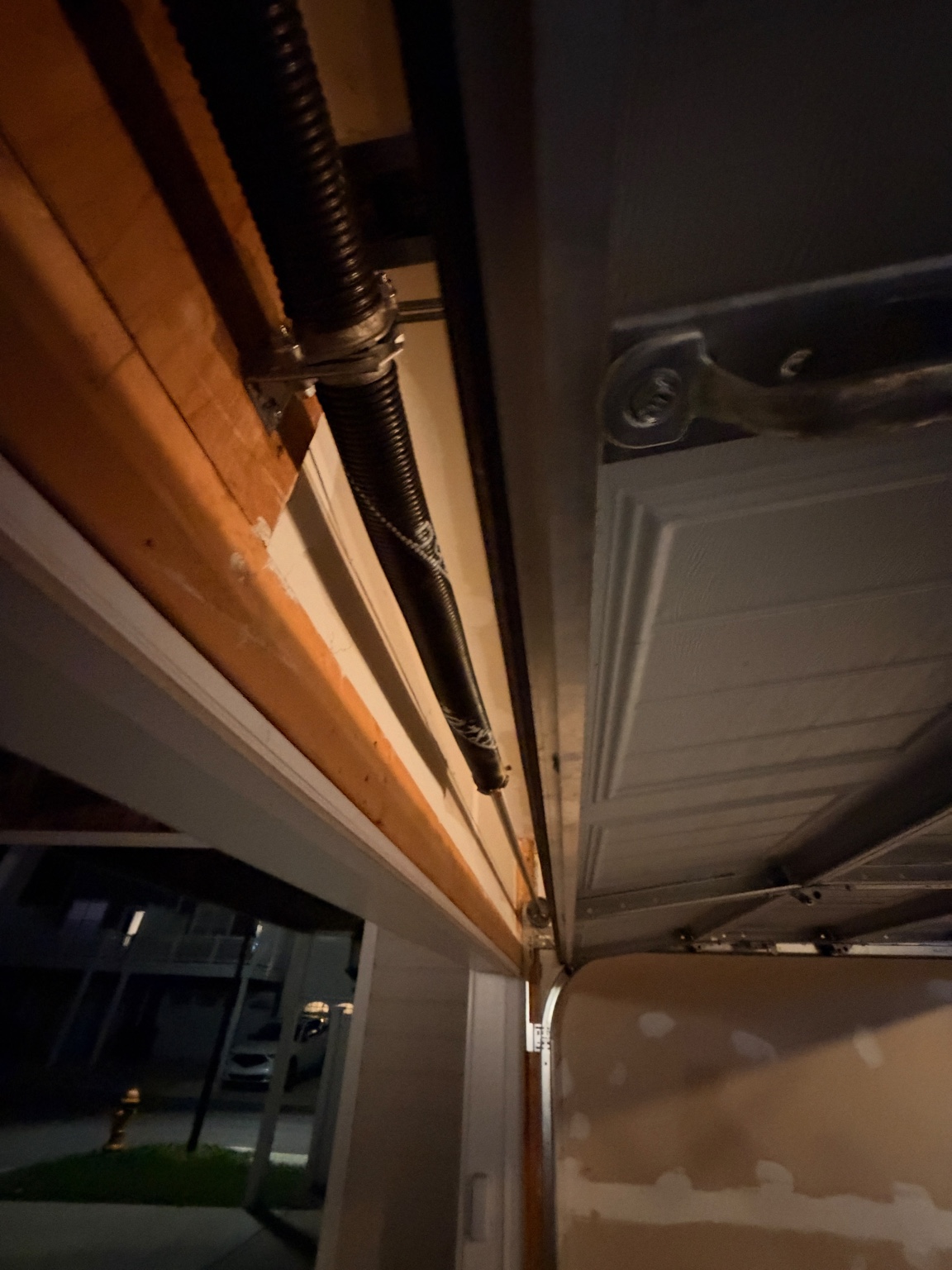 Close-up of a torsion spring and track above a garage door