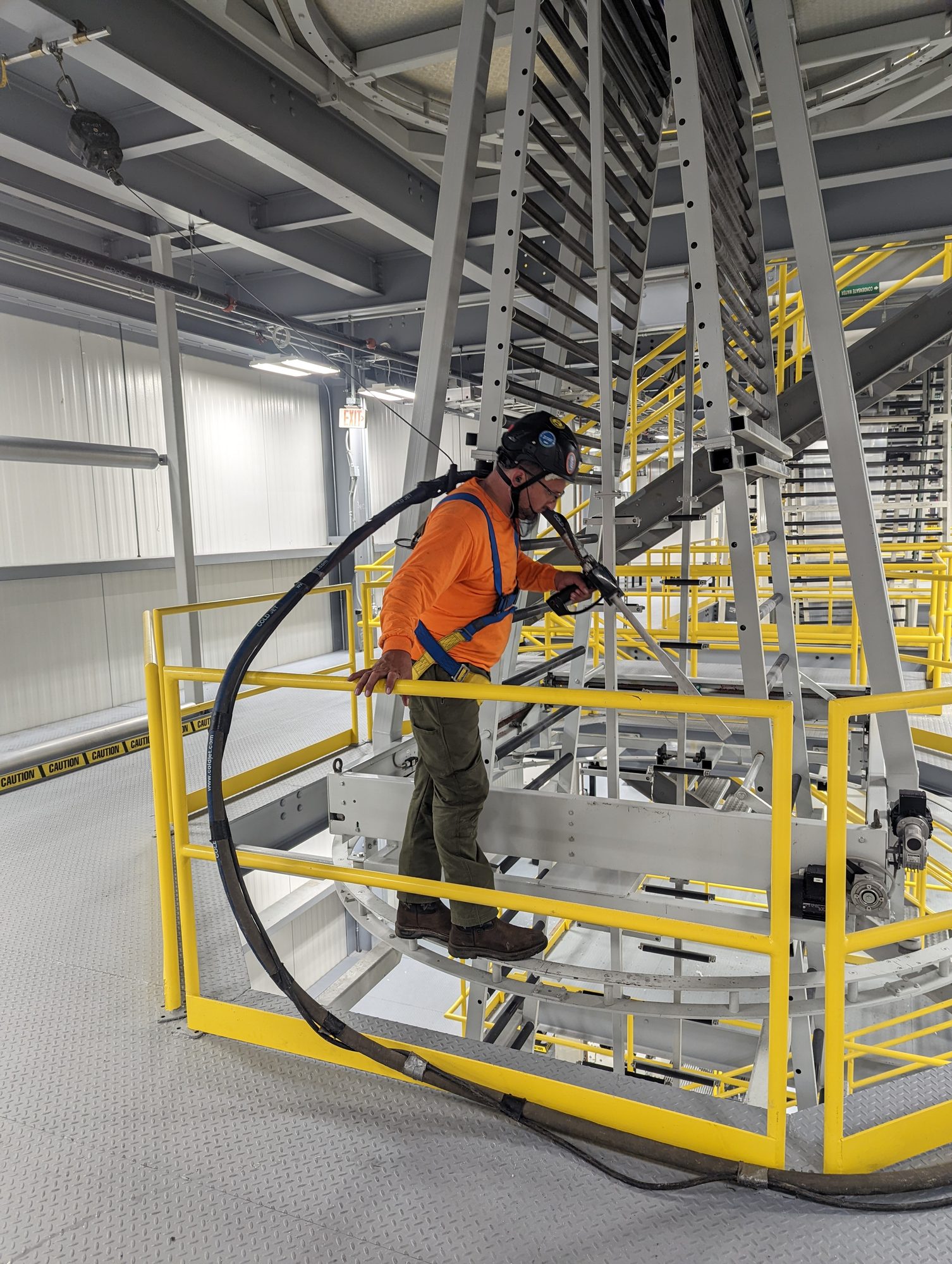 Technician dry ice blasting a film line tower