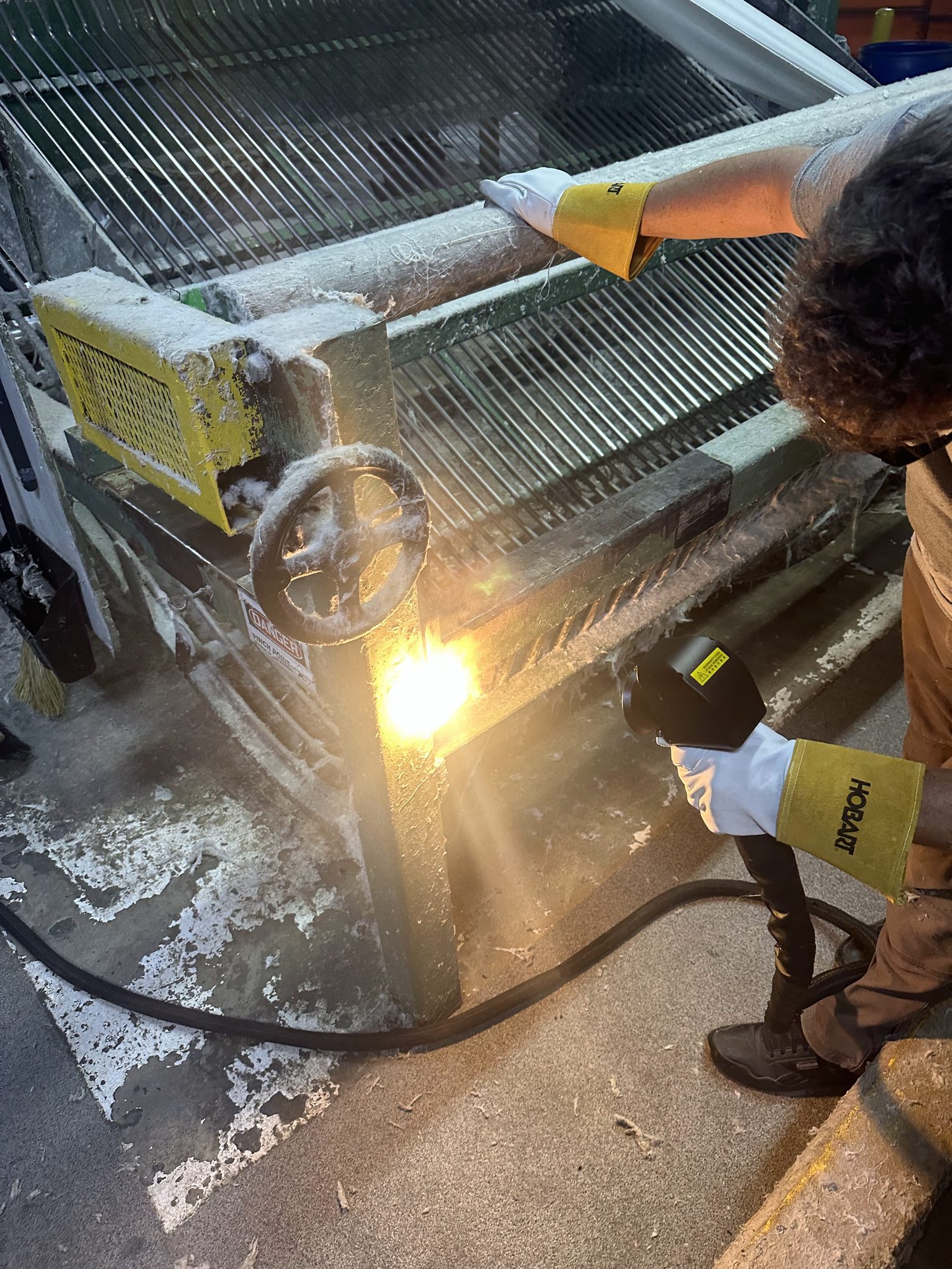 Technician laser cleaning a steel frame