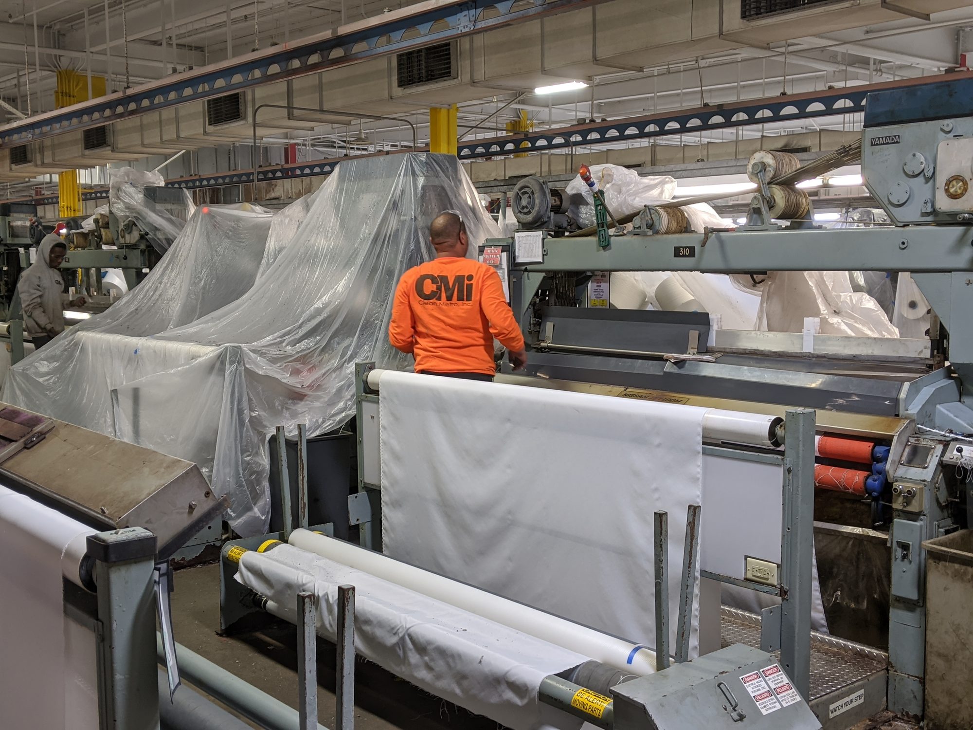 Crew cleaning textile looms during a shutdown