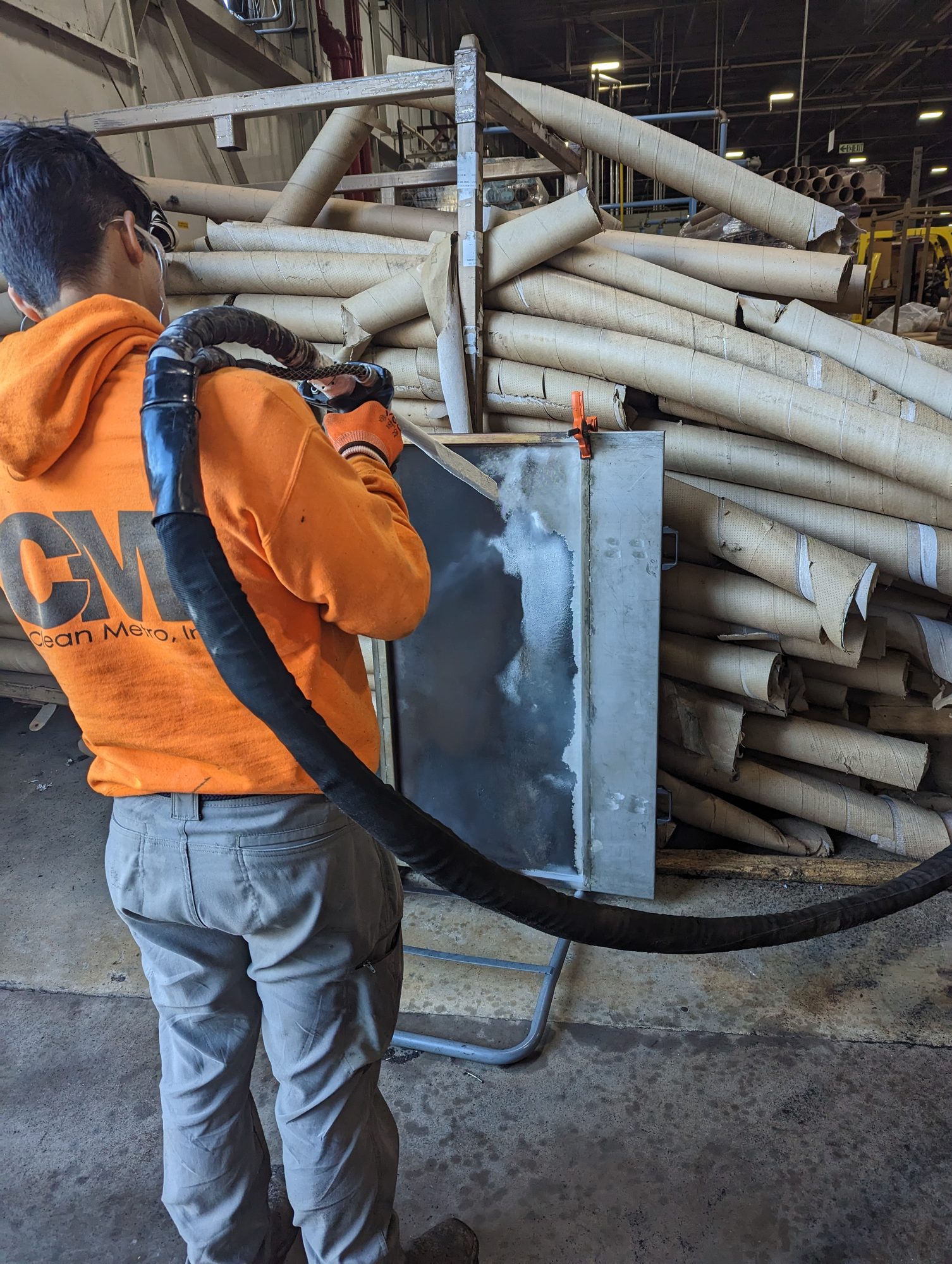 A CMI tech dry ice blasts a clogged metal filter screen back to bare mesh.
