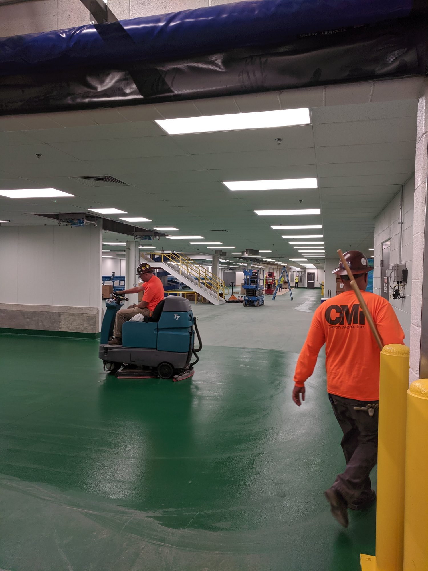 Ride-on scrubber cleaning a plant floor