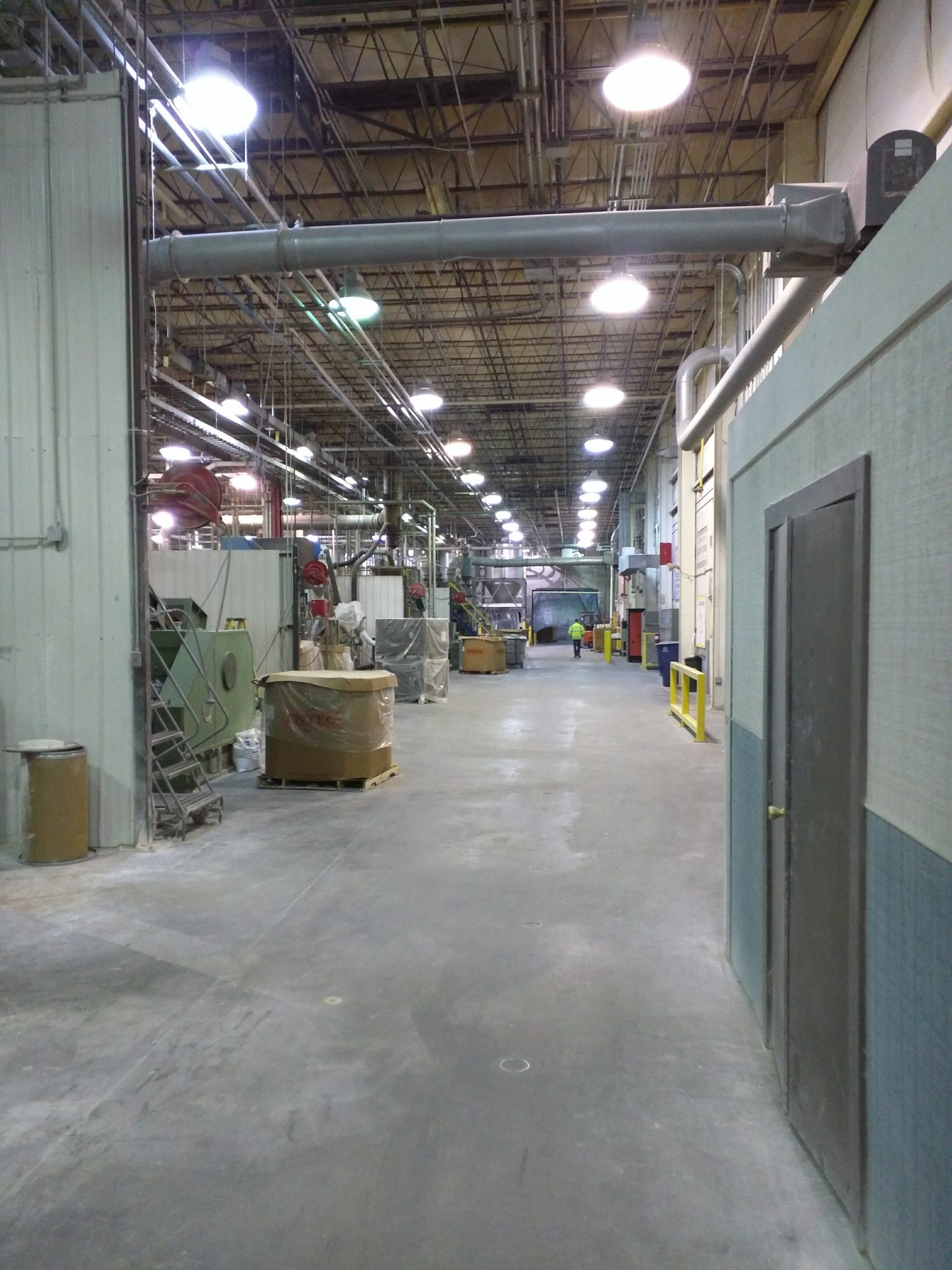 The same textile plant aisle after CMI's combustible dust cleanup, with the lint cleared.