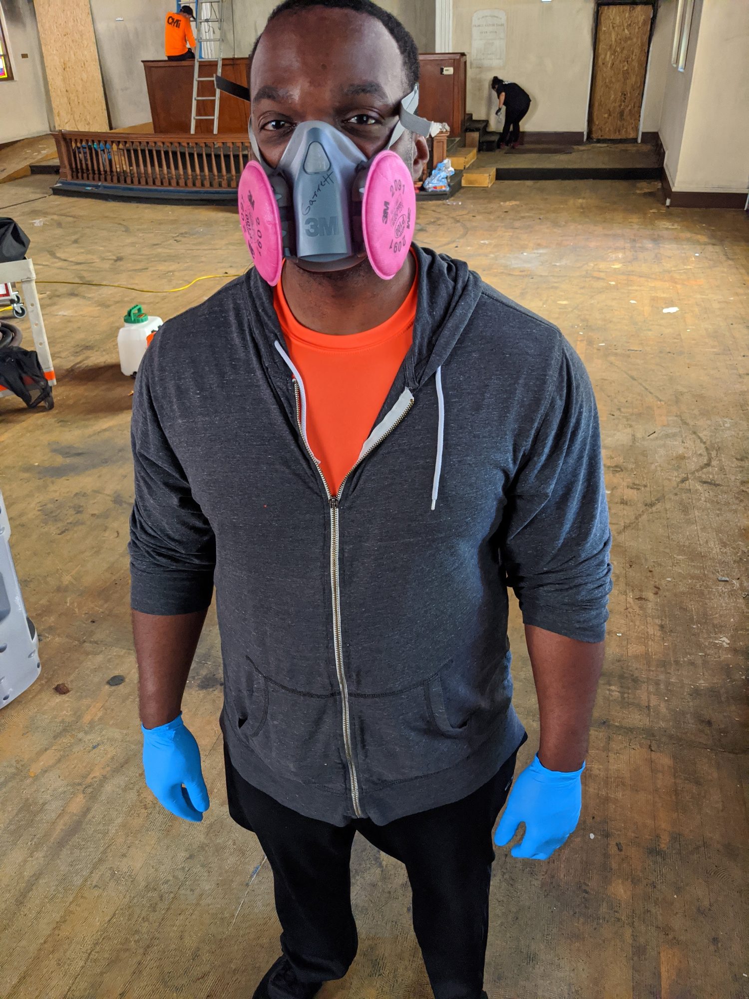 CMI tech in a half-face respirator and nitrile gloves on a church smoke and soot cleanup.