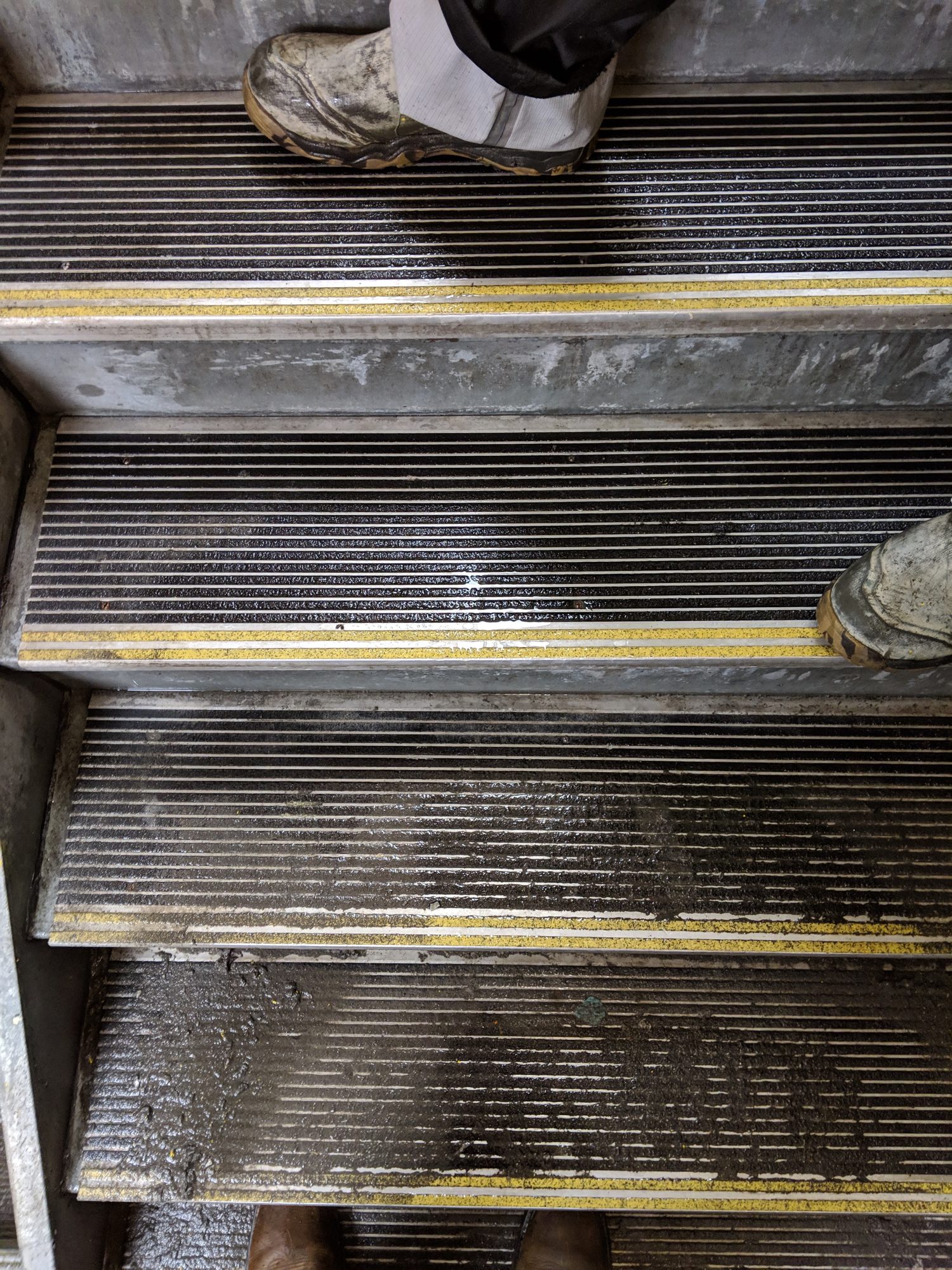 Before: steel stair treads caked with dried concrete slurry and mud.