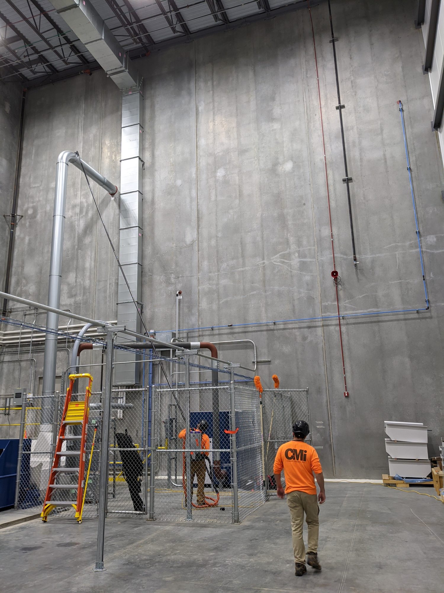 CMI tech crosses a 60-foot high-bay room during final clean of a new plant.