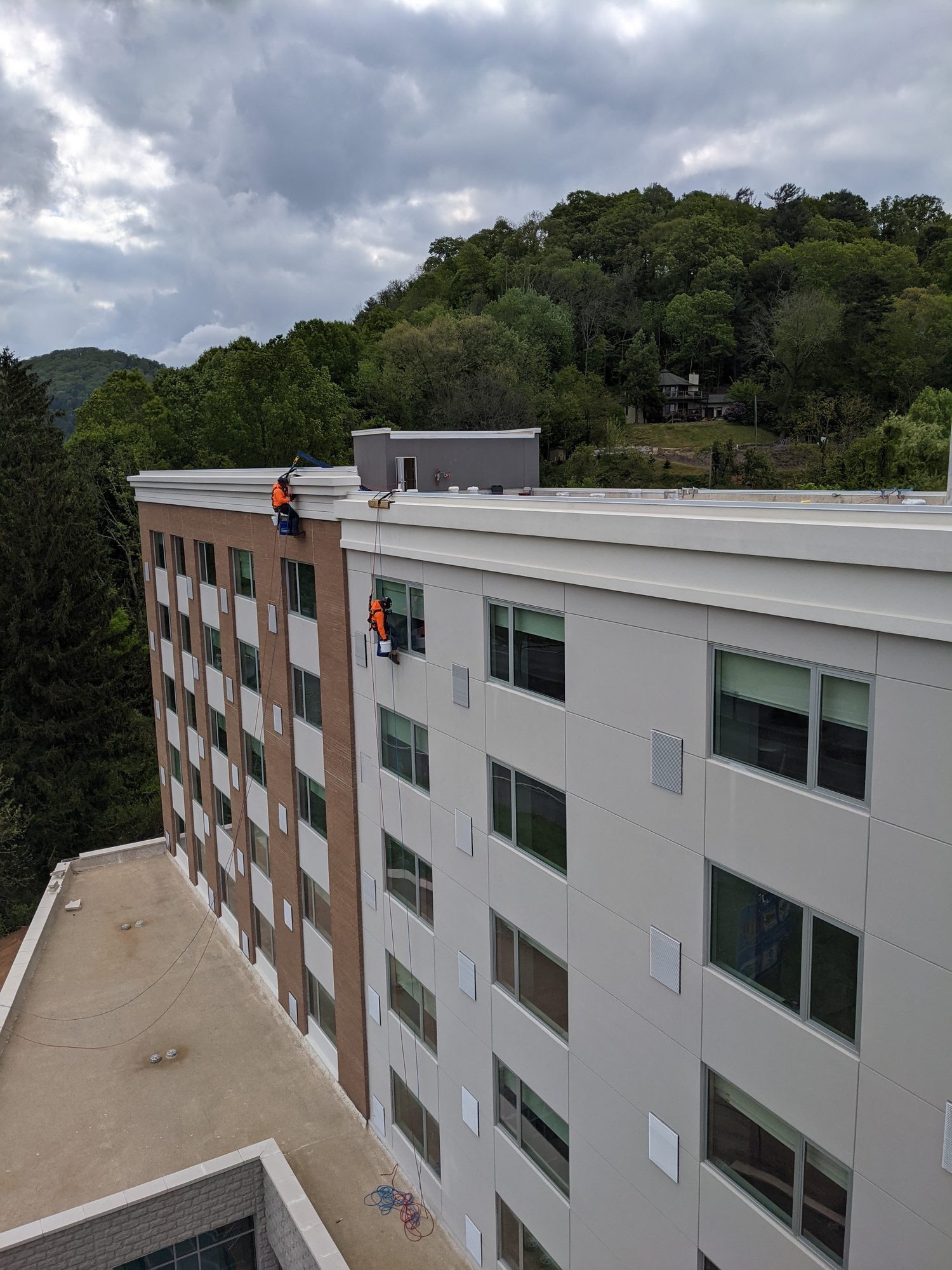 Rope access window cleaning on a new hotel facade.