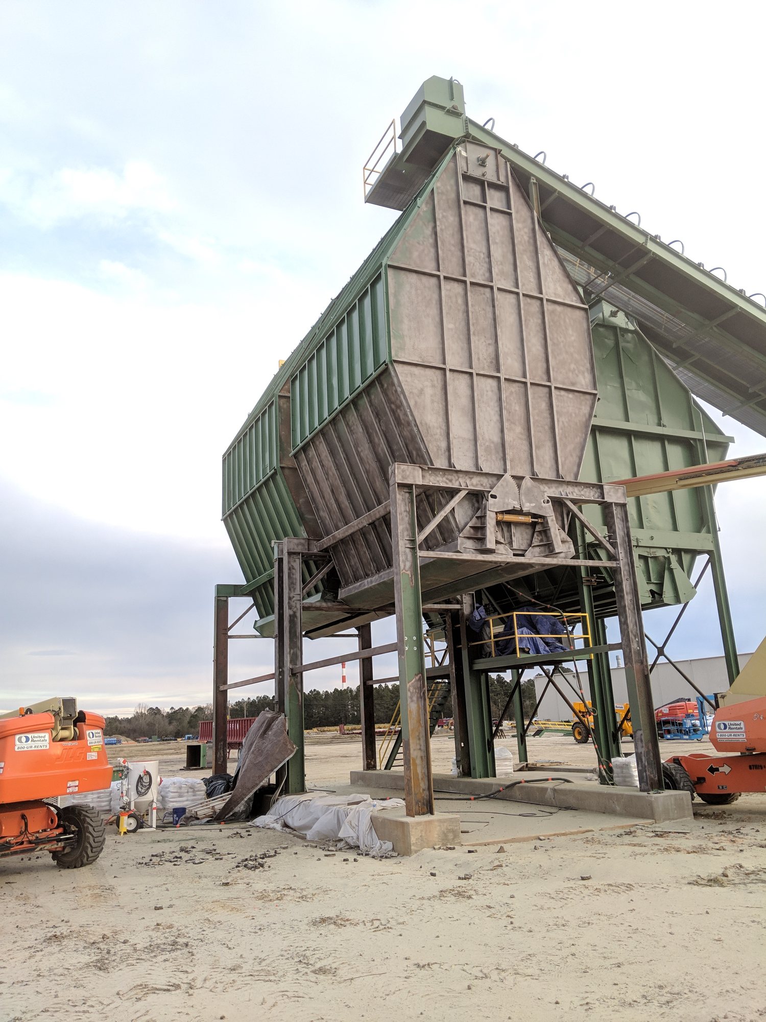 The hopper bottom shows blasted steel and fresh primer partway through recoating.