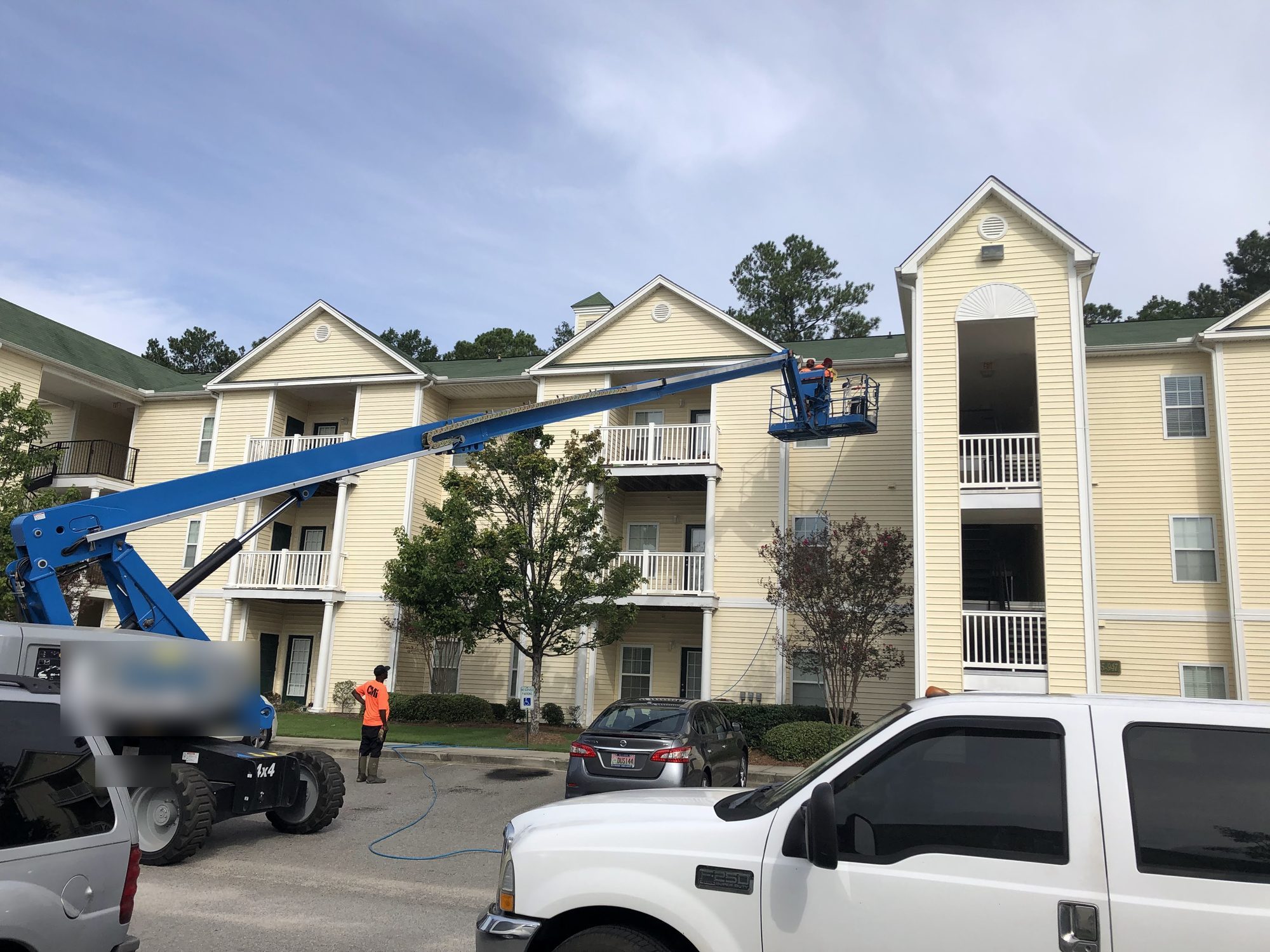 Boom lift on site at an occupied apartment complex. Crews cleaned 20 buildings with residents at home.