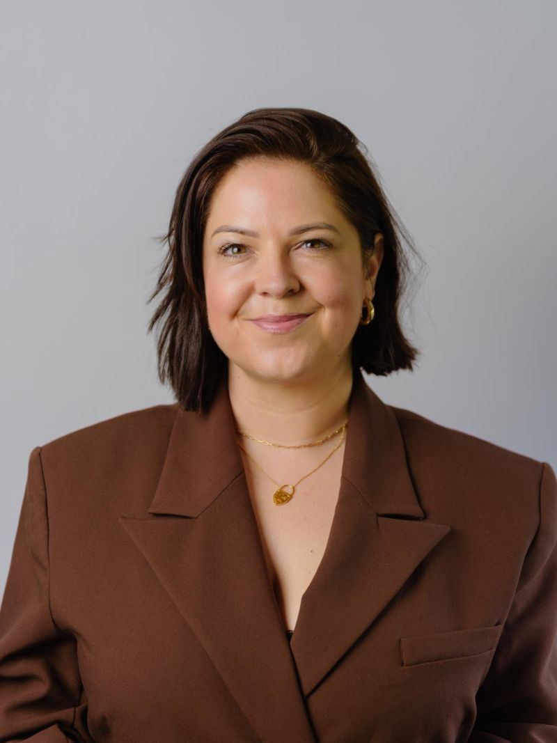 Leanne Cooper, Career Advancement Coach at You First Coaching, sitting outdoors with a cup of coffee.