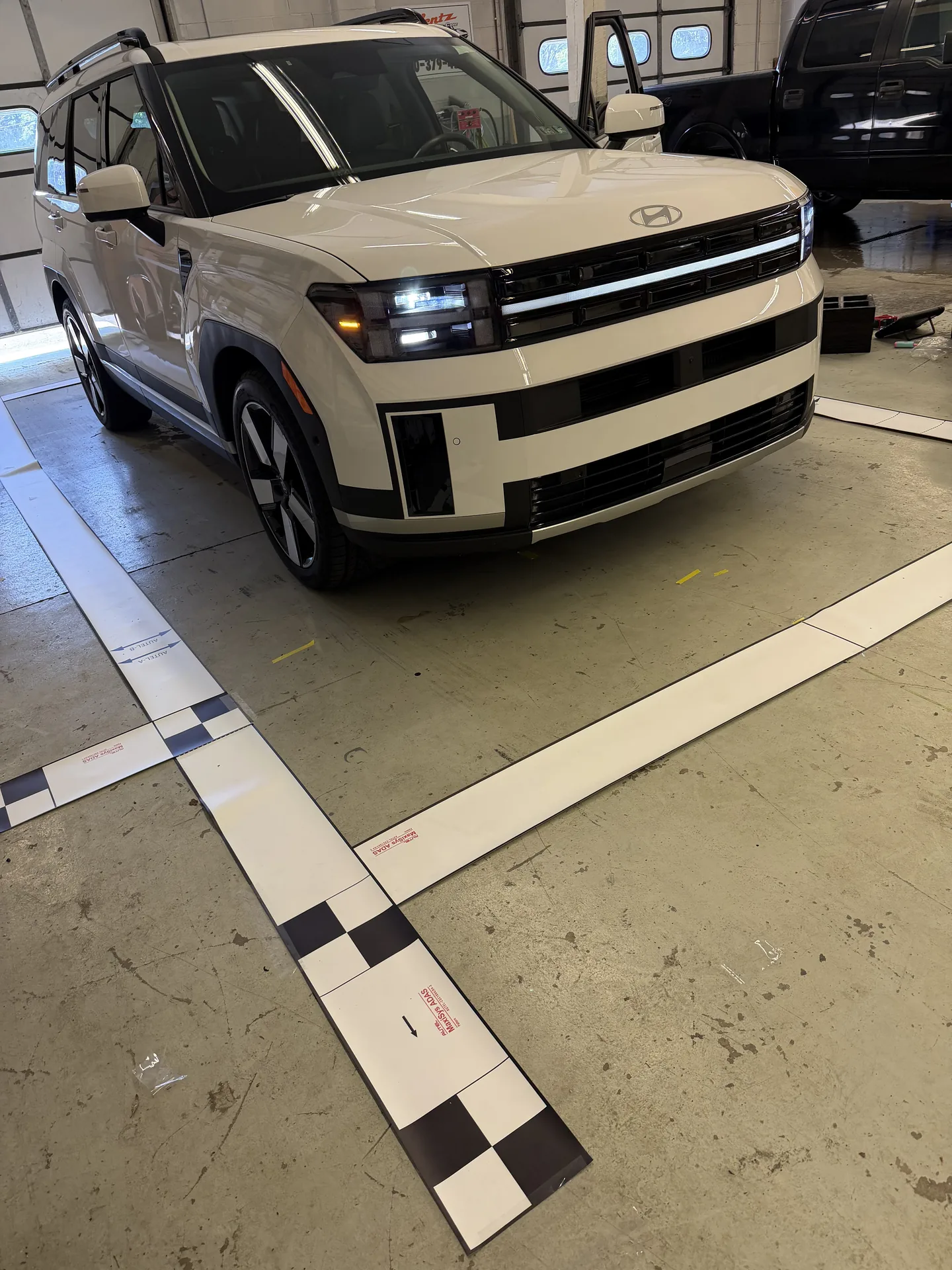 White Subaru Crosstrek in the shop with ADAS calibration targets behind it at Site Auto Glass Co.