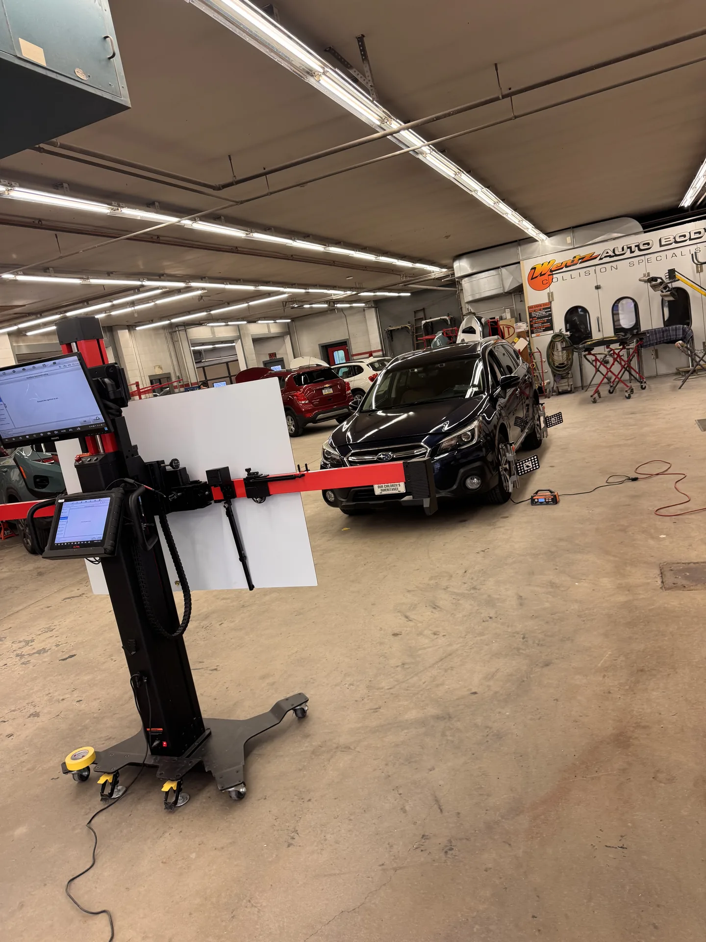 White Hyundai Palisade positioned on ADAS calibration floor tape at Site Auto Glass Co.