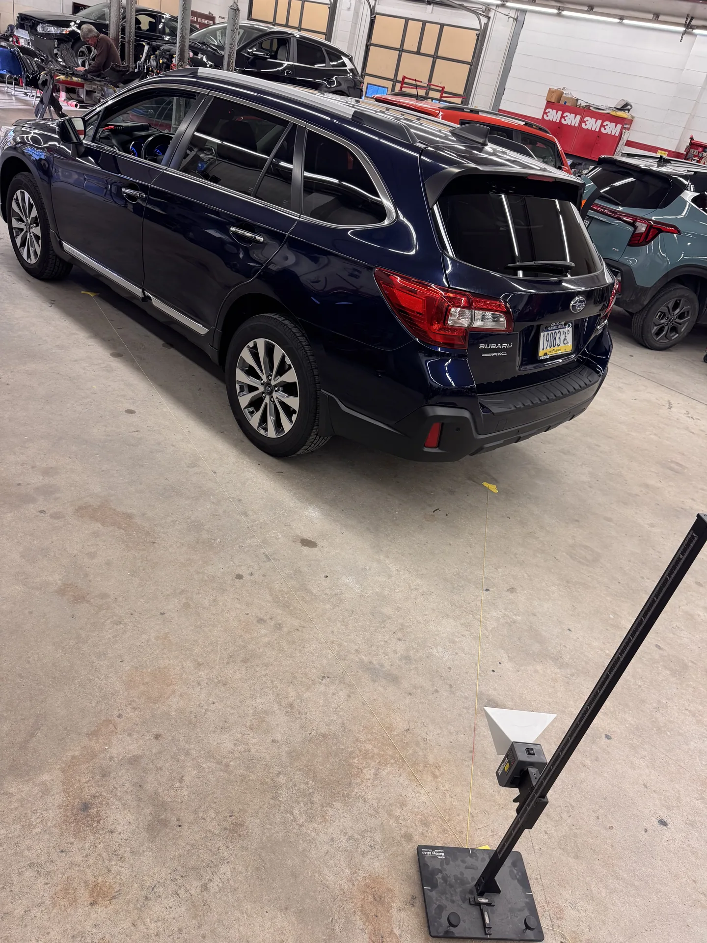 Black Subaru Crosstrek mid-ADAS-calibration with calibration rig in front at Site Auto Glass Co.