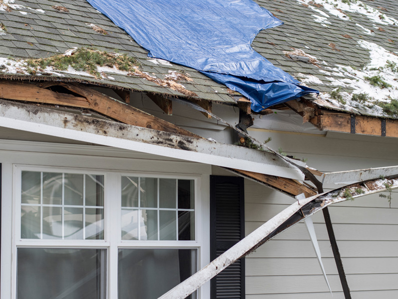 Storm-damaged roof before repair