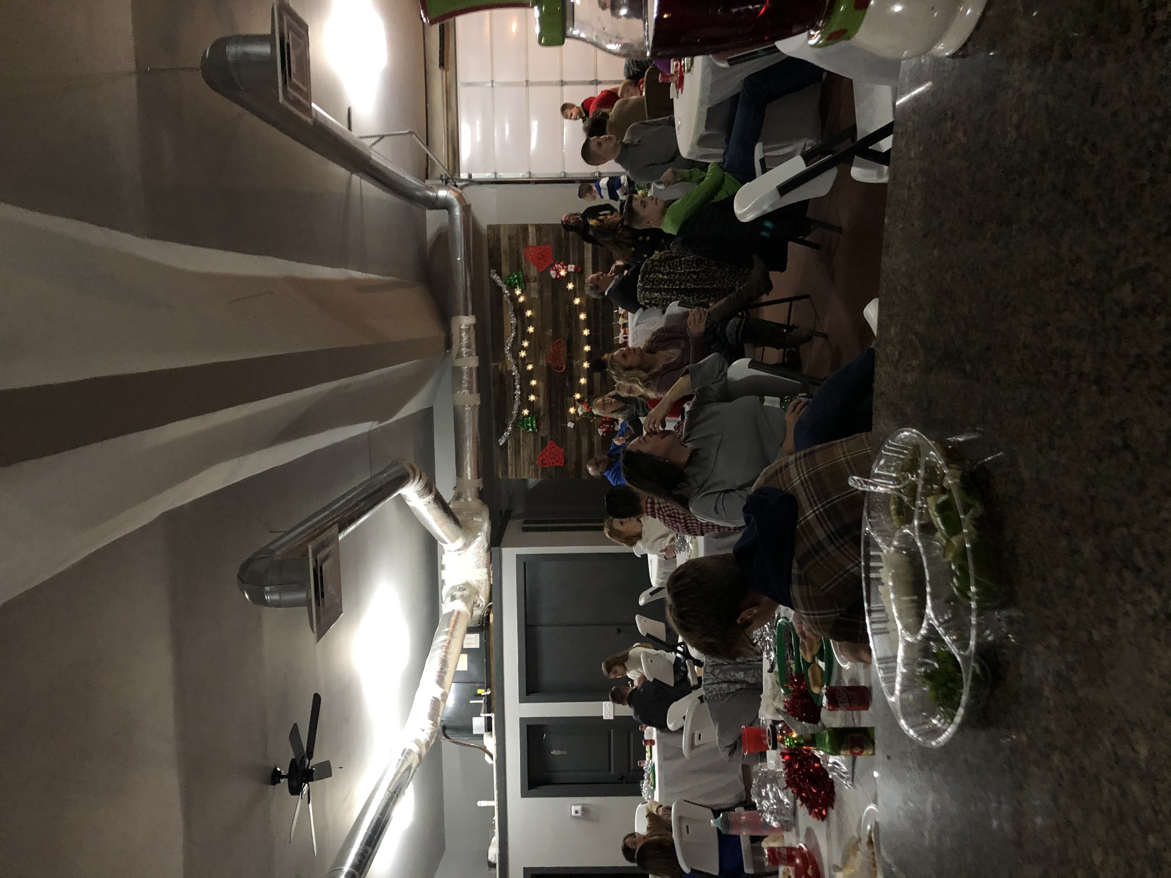 Evening gathering lit with string lights and greenery garland
