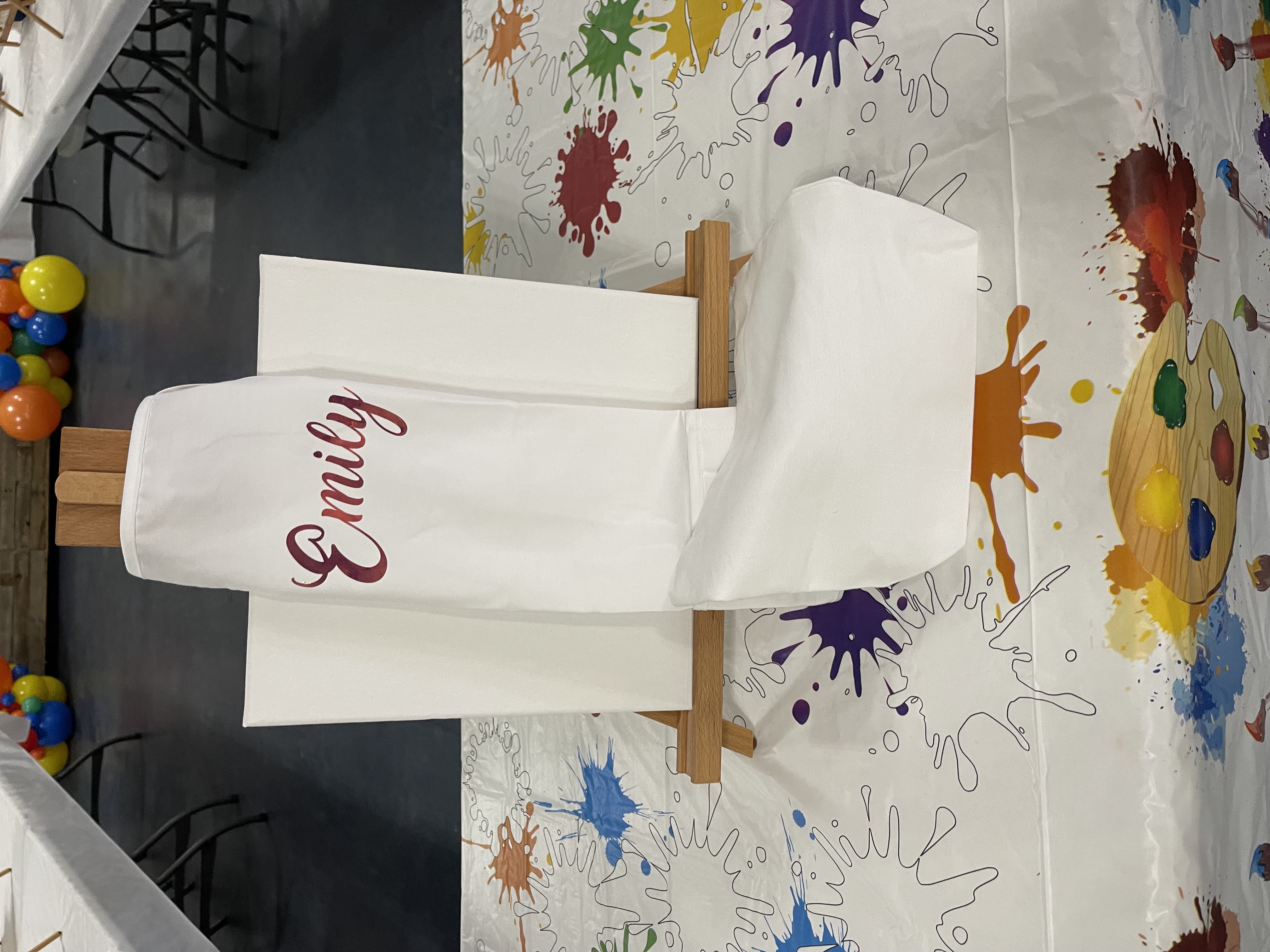 Paint party setup with a personalized canvas on an easel