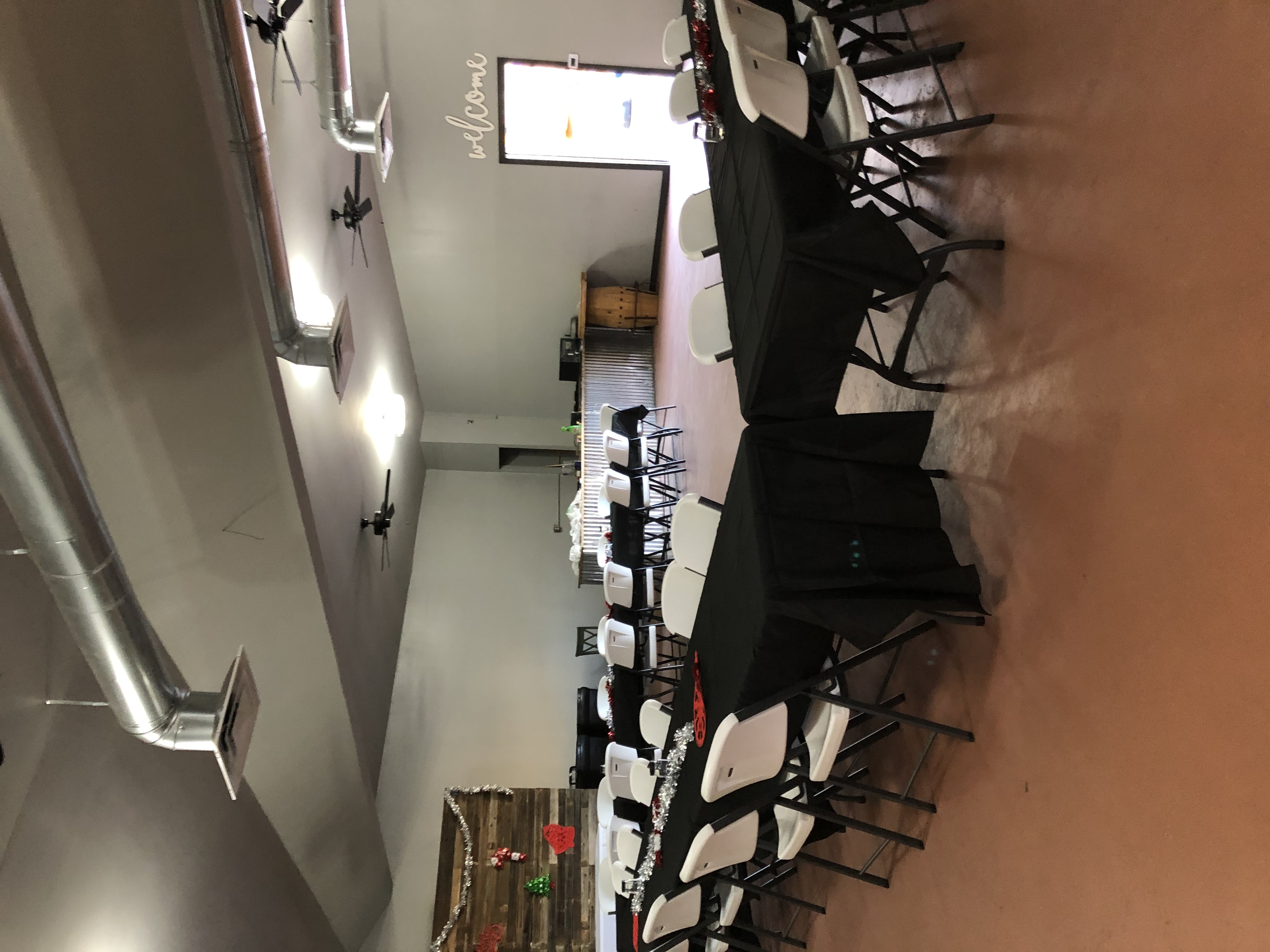 Long banquet tables and folding chairs arranged in the open event hall