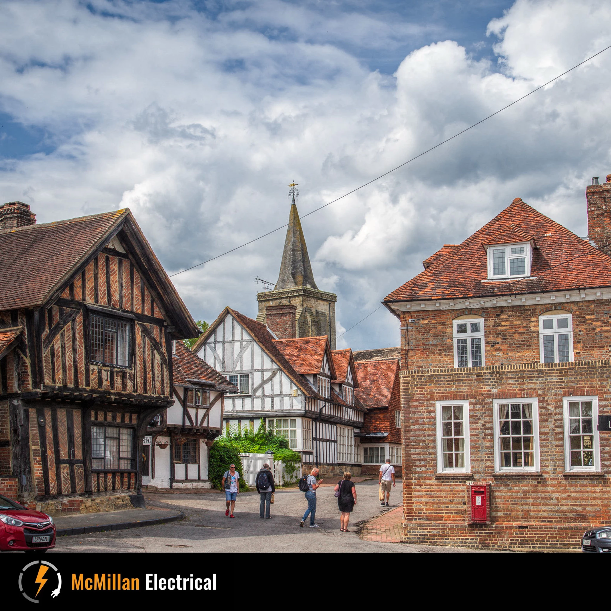 Historic timber-framed buildings and church in Lingfield village centre on a sunny day, served by McMillan Electrical for local electrical services.