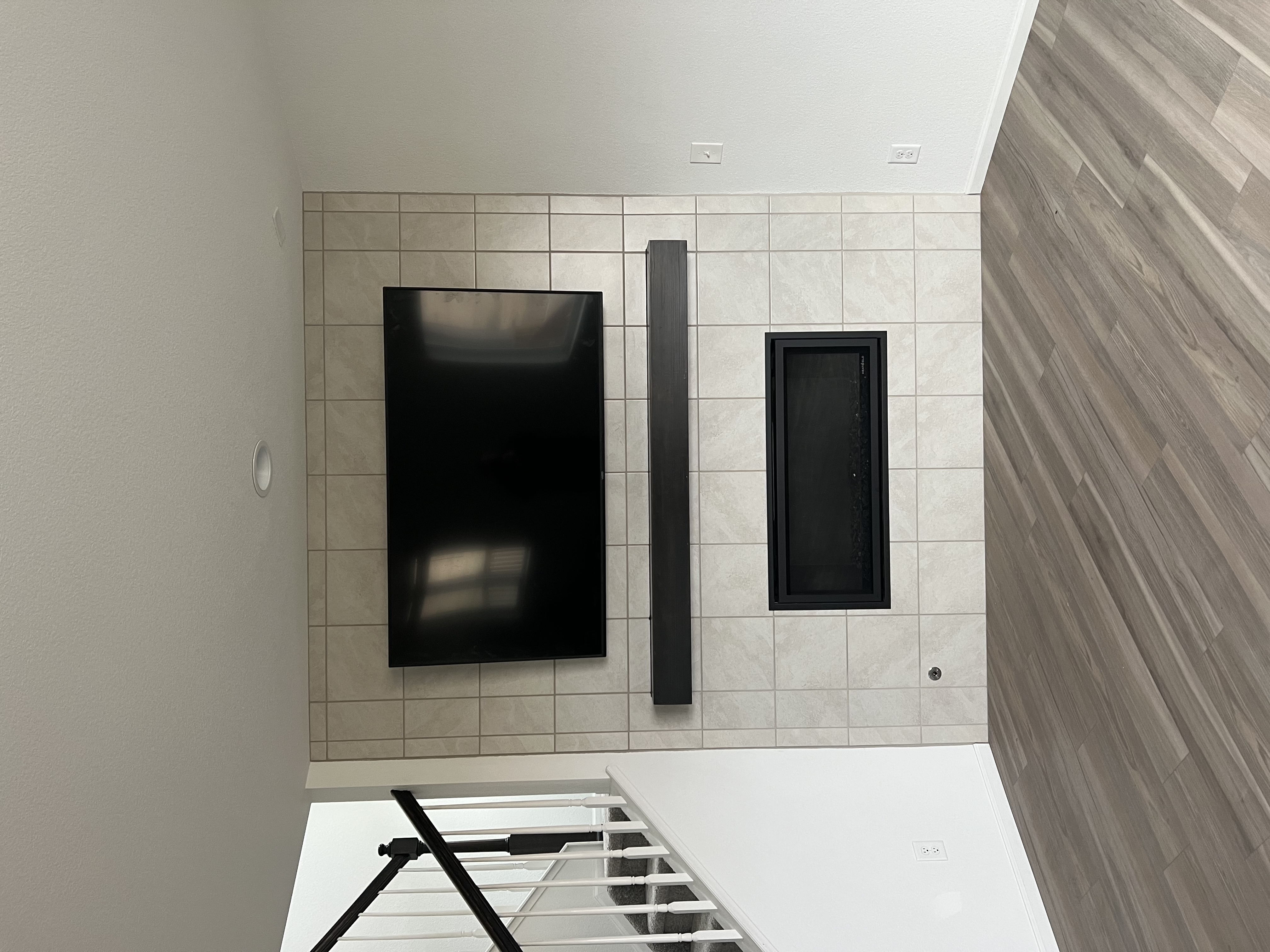 Family room TV installation with gaming setup and concealed cables by I Hang Flat Screens