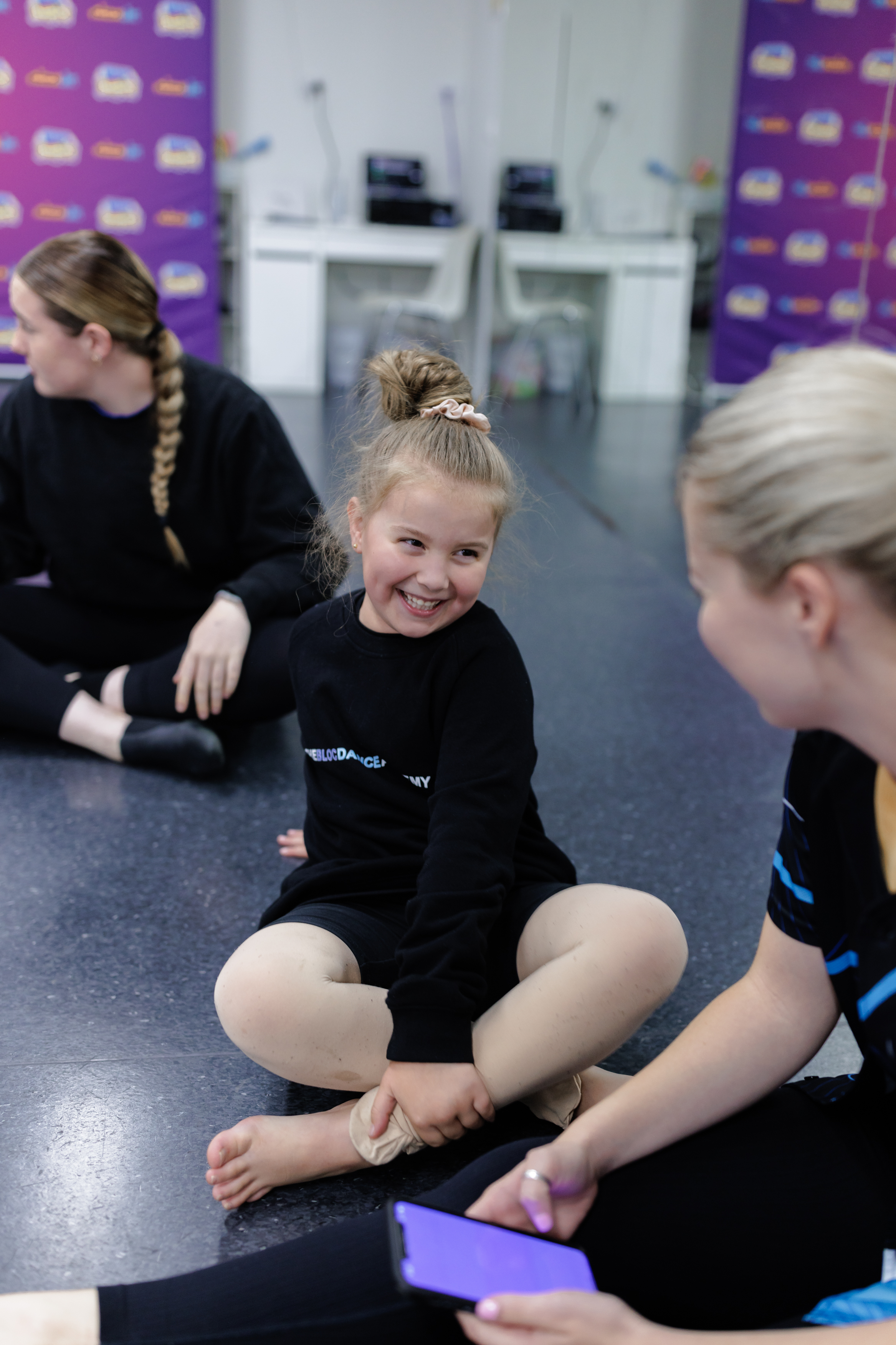 Kindergarten and Year 1 student smiling at their teacher during the roll-marking circle at KICO Dance Studios. Building confidence and connection through kids' dance classes in a supportive environment.