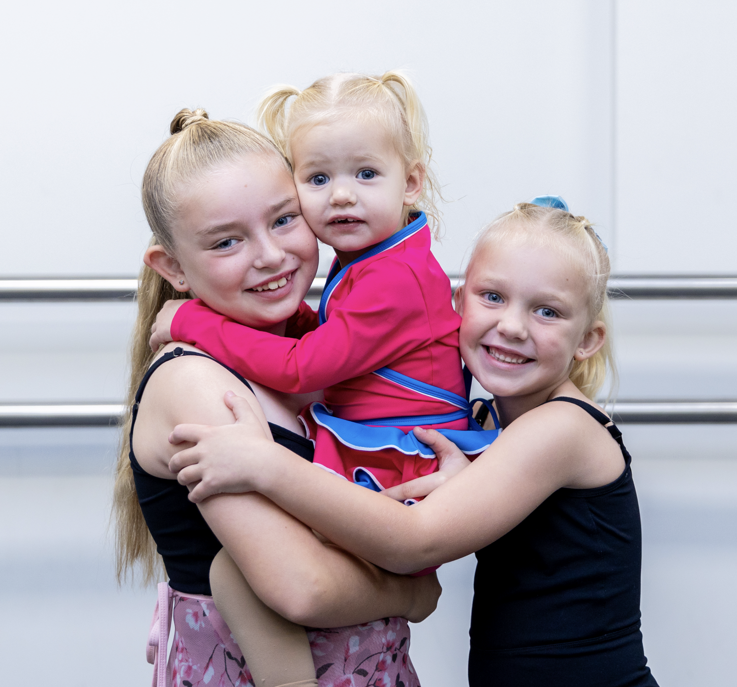 A happy family of three with girls of different ages, all taking kids' dance classes at KICO Dance Studios. The girls are building confidence and making lifelong friendships through pre-school and school-aged dance programs in a supportive environment