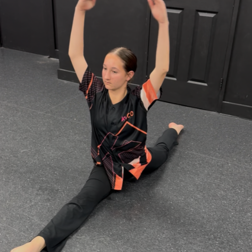 Young dancer practicing splits and arm technique on dance studio
