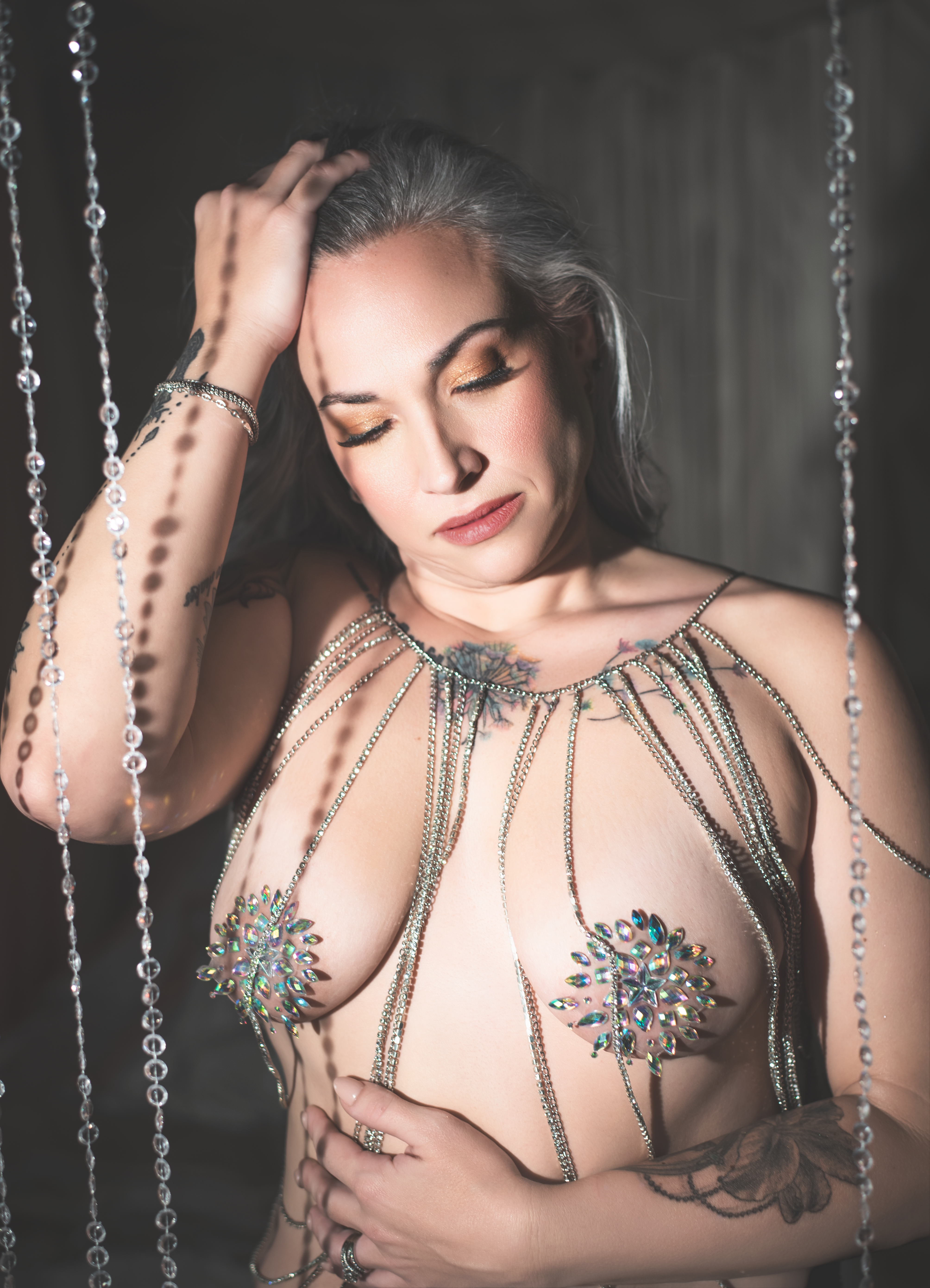 Moody boudoir portrait with woman wearing statement body chain in Atlanta studio.