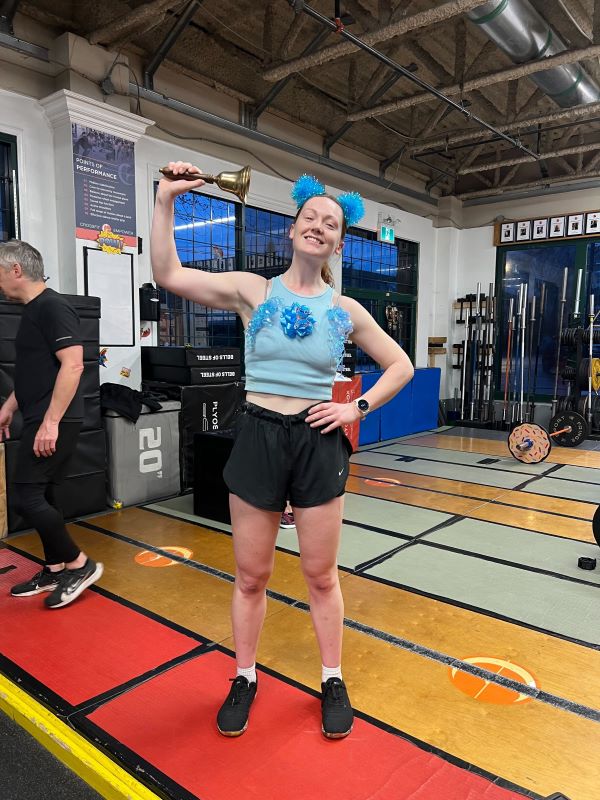 Superhero athlete ringing bell to denote new personal record