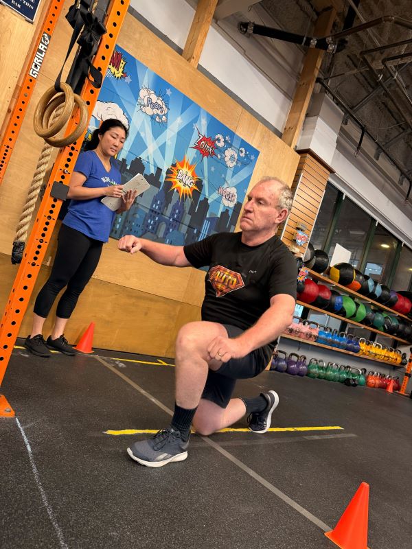 CrossFit member performing walking lunges across the starting line
