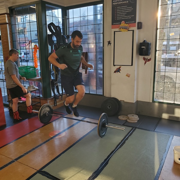 Empower athlete completing burpees over bar Empower athlete completing burpees over bar