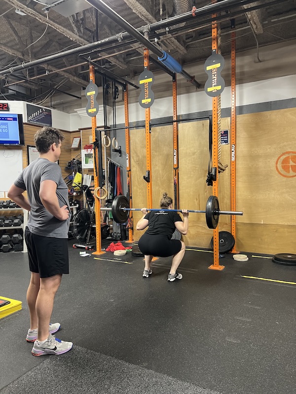 Empower athlete doing a back squat Empower athlete doing a back squat