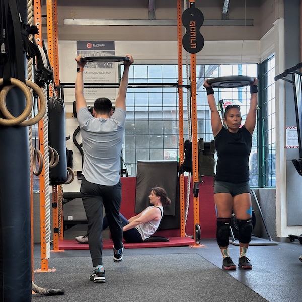 CrossFit group class overhead plate carry CrossFit group class overhead plate carry