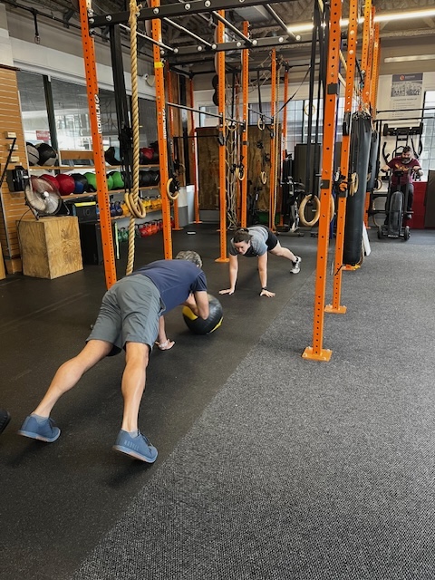 Partner med ball plank passes at Empower