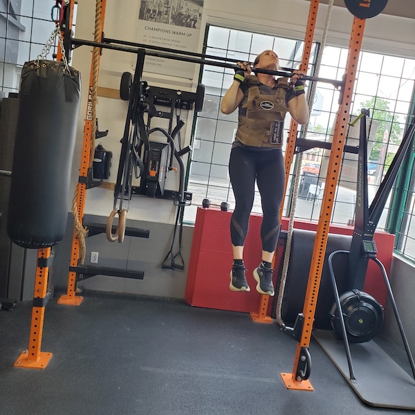 Empower athlete doing weighted pull up
