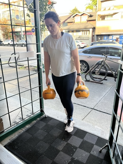 Kettlebell farmers carry with an Empower athlete