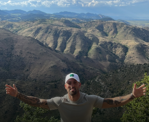 The climb — mountain summit, arms wide