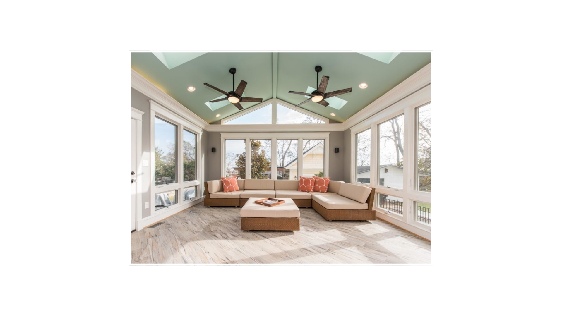 Custom sunroom interior with ceiling fans, natural light, and comfortable seating