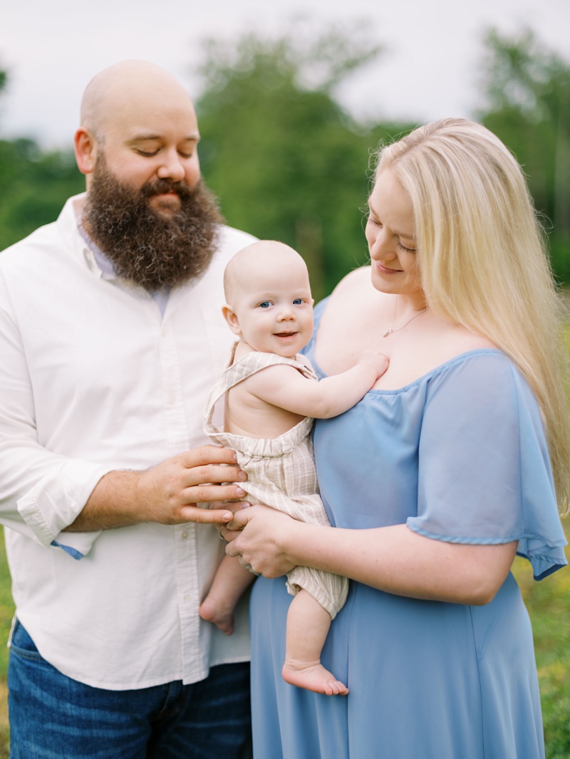 Mom and dad holding their baby during the best time of year for family photos in Northeast Tennessee Mom and dad holding their baby during the best time of year for family photos in Northeast Tennessee