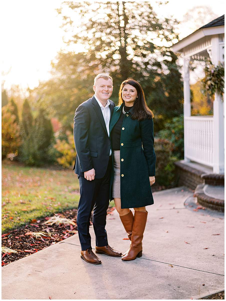 Engaged couple holding hands surrounded by colorful fall foliage