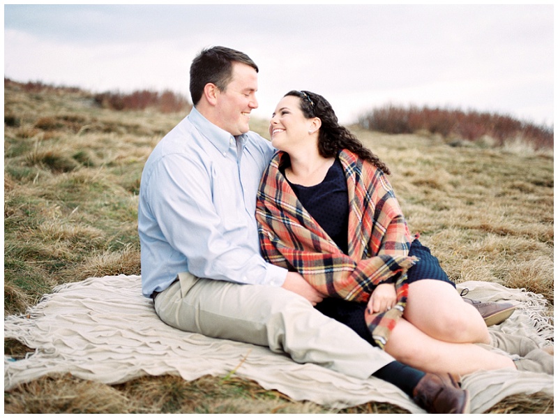 Engaged couple laughing together during mountain photo session