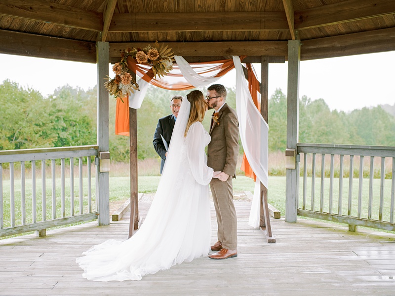 Couple kissing at their wedding ceremony at their natural tunnel state park wedding