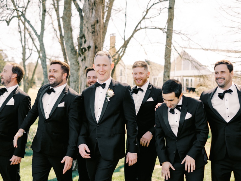 Groomsmen laughing together outdoors at Marblegate Farm