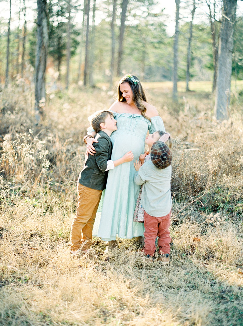 Siblings hugging mom’s baby bump Siblings hugging mom’s baby bump