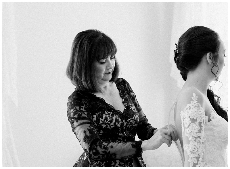 mother of the bride helping her with dress
