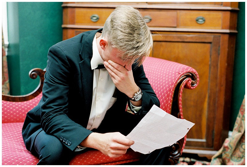 Emotional groom on wedding day reading letter from bride
